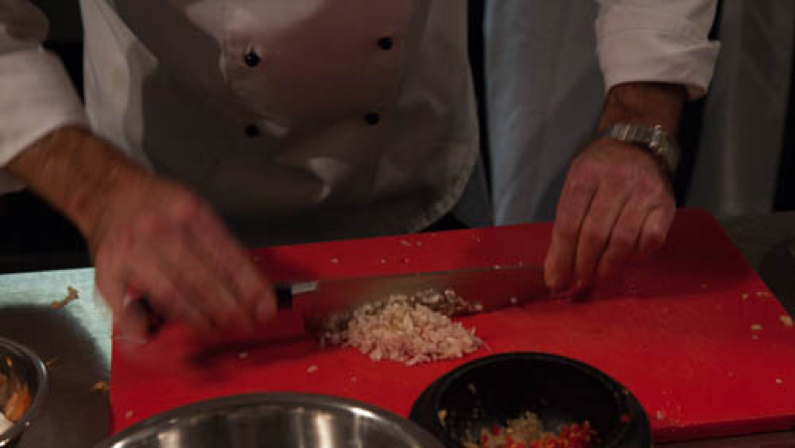Knoflook fijnsnijden op een rode snijplank