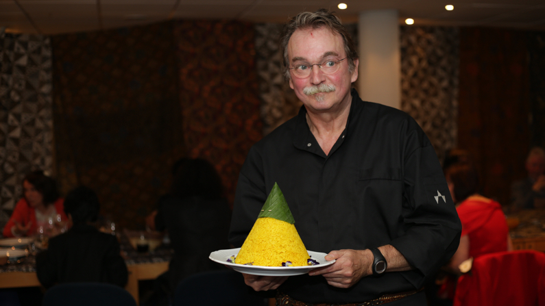Rob brengt de tumpeng van gele rijst naar de feestzaal