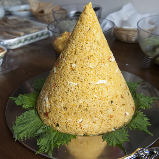 Tumpeng: kegel van gele rijst op bananenblad