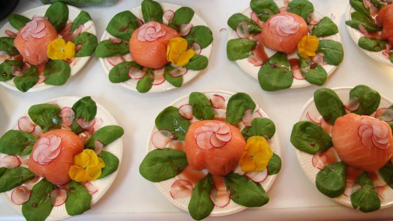 Borden met roosjes van zalm en eetbare bloemen