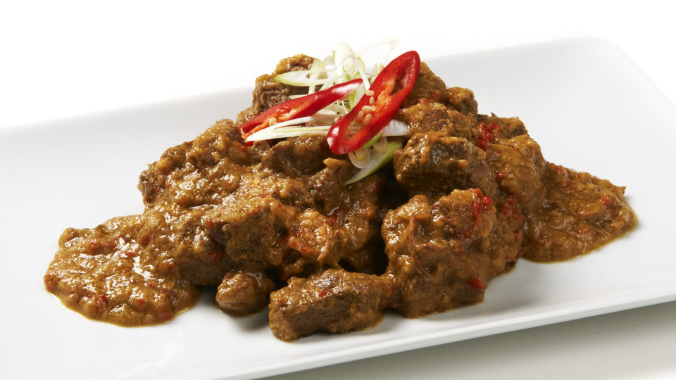 Daging Rendang: stukjes rundvlees in dikke kruidensaus op een witte schaal