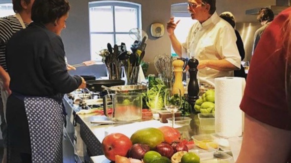 Rob geeft uitleg aan deelnemers tijdens een kookworkshop