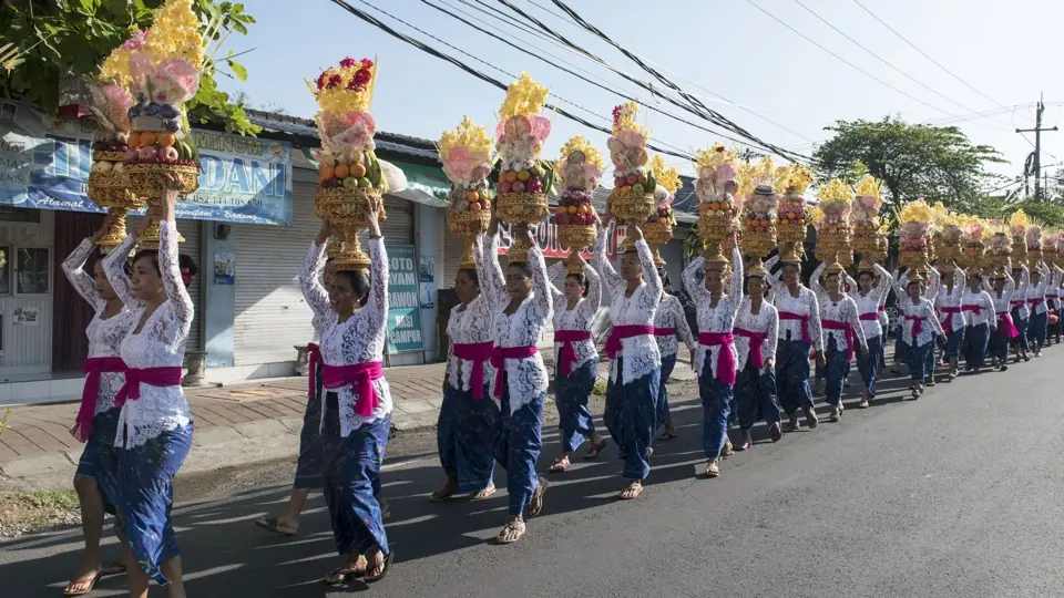 Balinese vrouwen dragen kleurrijke offergaven naar een tempelceremonie.