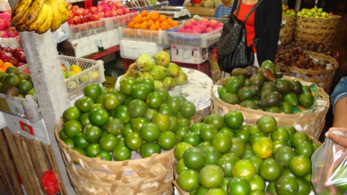Manden met limoenen, mango's en ander fruit op een Balinese markt