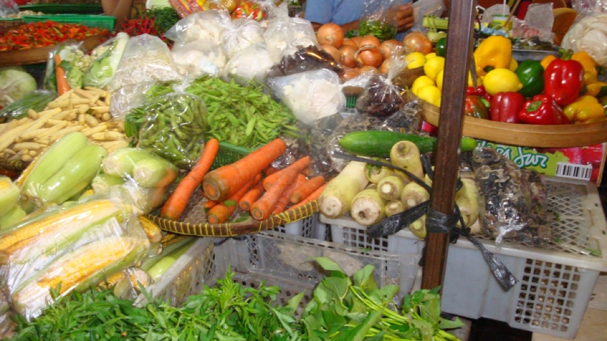 Kraam met kool, wortelen, maïs, paprika en bladgroenten op een Balinese markt