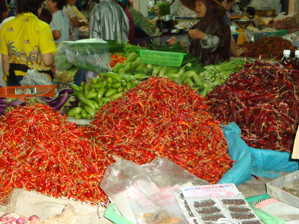 Bergen rode en groene pepers op een markt in Thailand