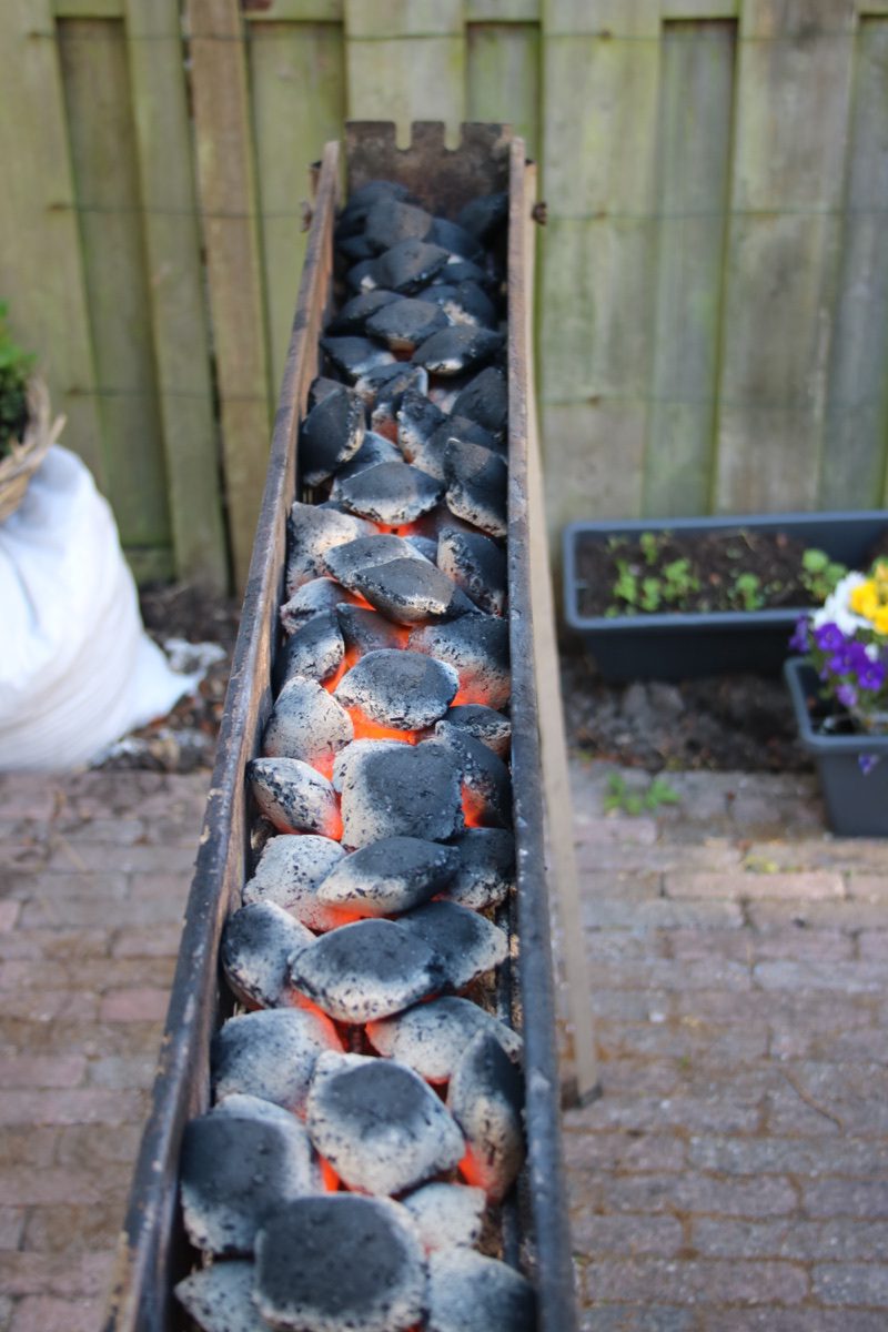 Kleine satégrill met gloeiende briketten van kokosbast